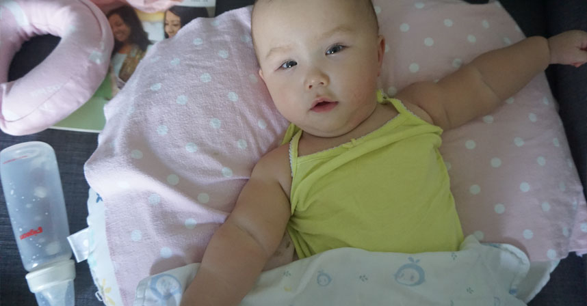 Aspiration after feeding | AADC News | Rylae-Ann is pictured in a yellow top and supported by a pink pillow
