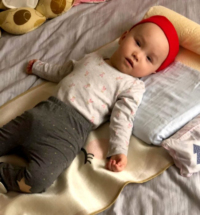 AADC News | Rylae-Ann rests against a foam wedge for support and to help keep her upright at a 45-degree angle