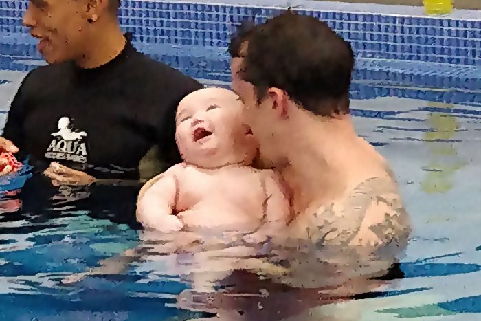 water therapy | AADC News | Richard holds Rylae-Ann in the pool as a professional aqua therapist delivers instructions.