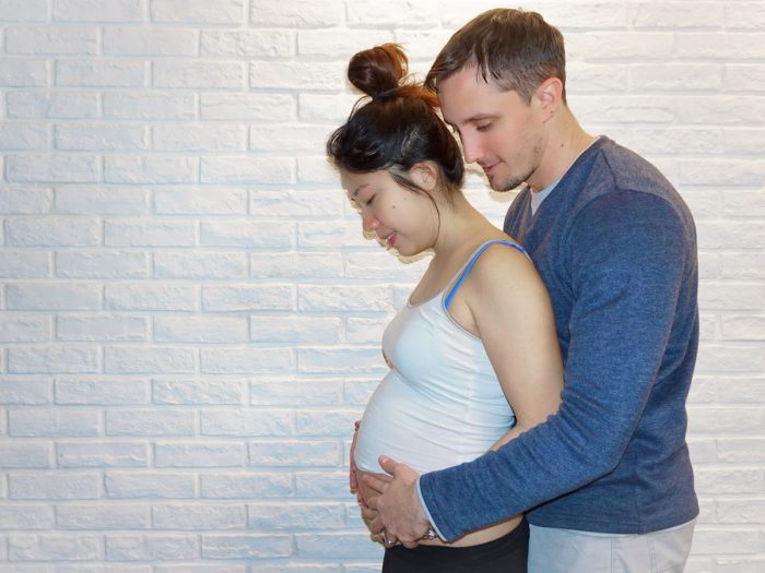 genetic testing | AADC News | Richard and his wife pose with their hands on her belly during her pregnancy.