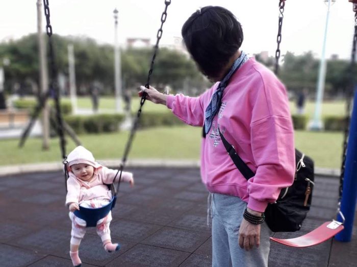support network | AADC News | A family member pushes Rylae-Ann on a swing in the park. Both are wearing pink, and Rylae-Ann is smiling.