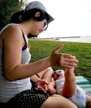 anxiety and AADC deficiency | AADC News | Rylae-Ann and her mom sit on the grass near the beach and do stretching exercises together.
