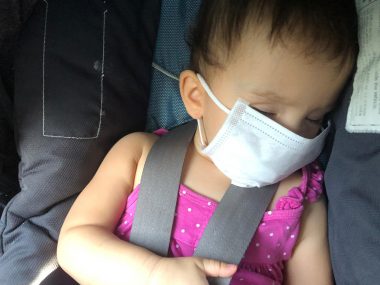 finding a doctor | AADC News | Rylae-Ann wears a surgical mask as she naps after a doctor appointment