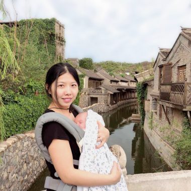 friendships | AADC News | Judy holds Rylae-Ann in front of a canal in a village in China