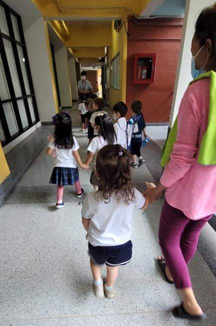 nanny | AADC News | Rylae-Ann follows her classmates down the hall at school while holding hands with her nanny.