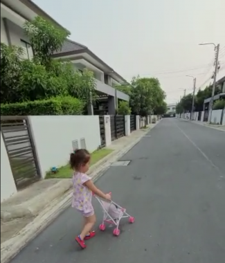AADC News | Dressed in a cute pink outfit, Rylae-Ann pushes a pink doll stroller down the street 