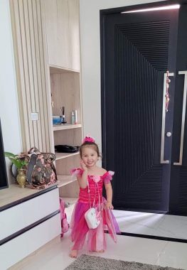 AADC deficiency diagnosis | AADC News | A recent photo of an older Rylae-Ann smiling and dressed in a pink princess dress.