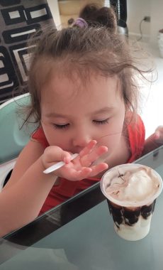 diet and AADC deficiency | AADC News | Her hair in a ponytail, Rylae-Ann eats an ice cream sundae that has been mixed with vitamin B6