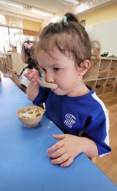 | AADC News | Rylae-Ann slurps a cereal spoon while eating breakfast