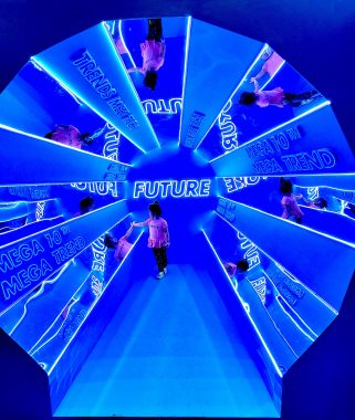 nature versus nurture debate | AADC News | Rylae-Ann walks through a very blue art installation that looks like a mirrored tunnel, with the word "Future" appearing throughout