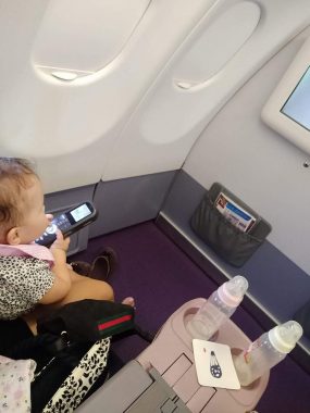 children with special needs | AADC News | photo of Rylae-Ann with on an airplane with a remote in her hands, with a roomy space in front of her