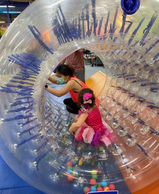 indoor playgrounds | AADC News | Rylae-Ann and her mother play together in a large clear tube at an indoor playground