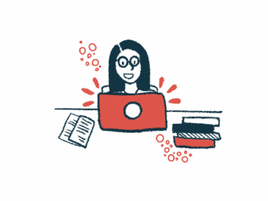 A woman sits at her computer with books and papers scattered around.