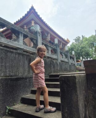 Rylae-Ann climbs steps to a temple in Taiwan during a summer trip in 2023.