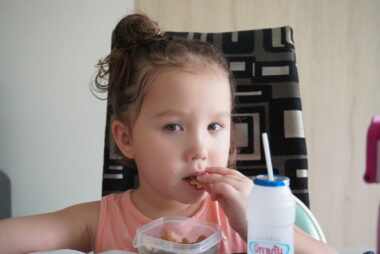 A photo of a child having a snack.