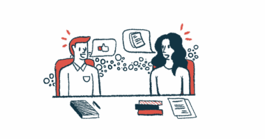 Two people sit at a table talking.