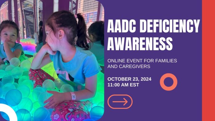 A young girl with a ponytail wearing a light blue T-shirt and red pants with multicolored designs looks into a mirror, her chin resting on her hand. She appears to be sitting amid glowing light green orbs. At right is a dark purple square with white words saying, "AADC DEFICIENCY AWARENESS" followed by "ONLINE EVENT FOR FAMILIES AND CAREGIVERS" and "OCTOBER 23, 2024 11:00 AM EST." A red vertical bar is at the far right. 