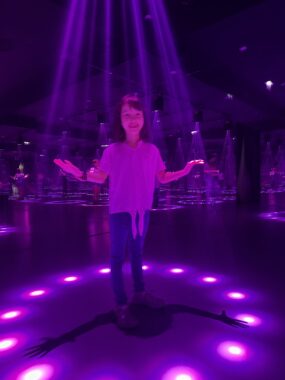 A young child stands inside a circle of lights.