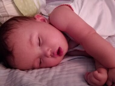 A baby sleeps on a foam memory wedge