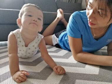 A young child and a woman lie on the floor with their heads up.