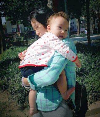 A woman hold a baby in her arms.