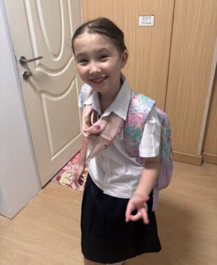 a young girl is shown wearing a school uniform.