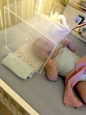 A baby wails inside of a nebulised medicine box.